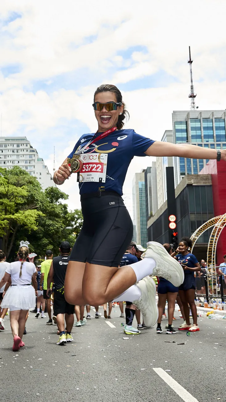 Atleta comemorando de salto na Avenida Paulista durante a São Silvestre